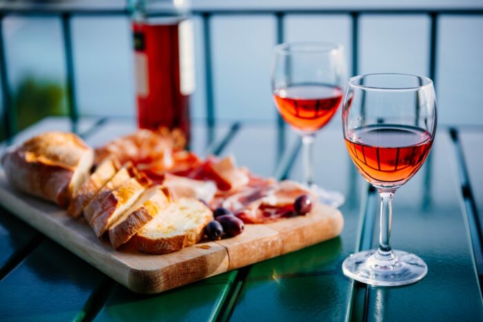 two glasses of wine and italian snacks with amazing view at sunset in italy